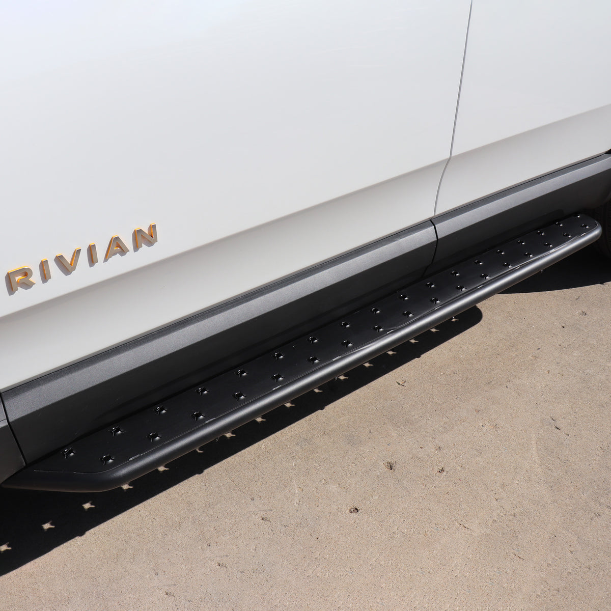 Stainless Steel running boards installed on rivian glacier white R1S