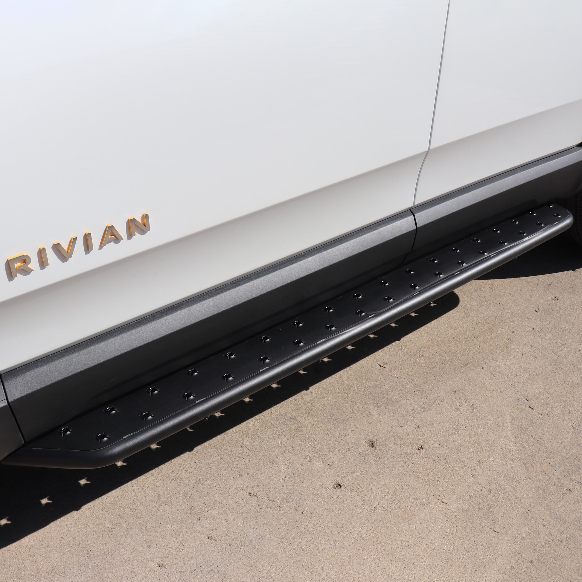 Stainless Steel running boards installed on rivian glacier white R1S